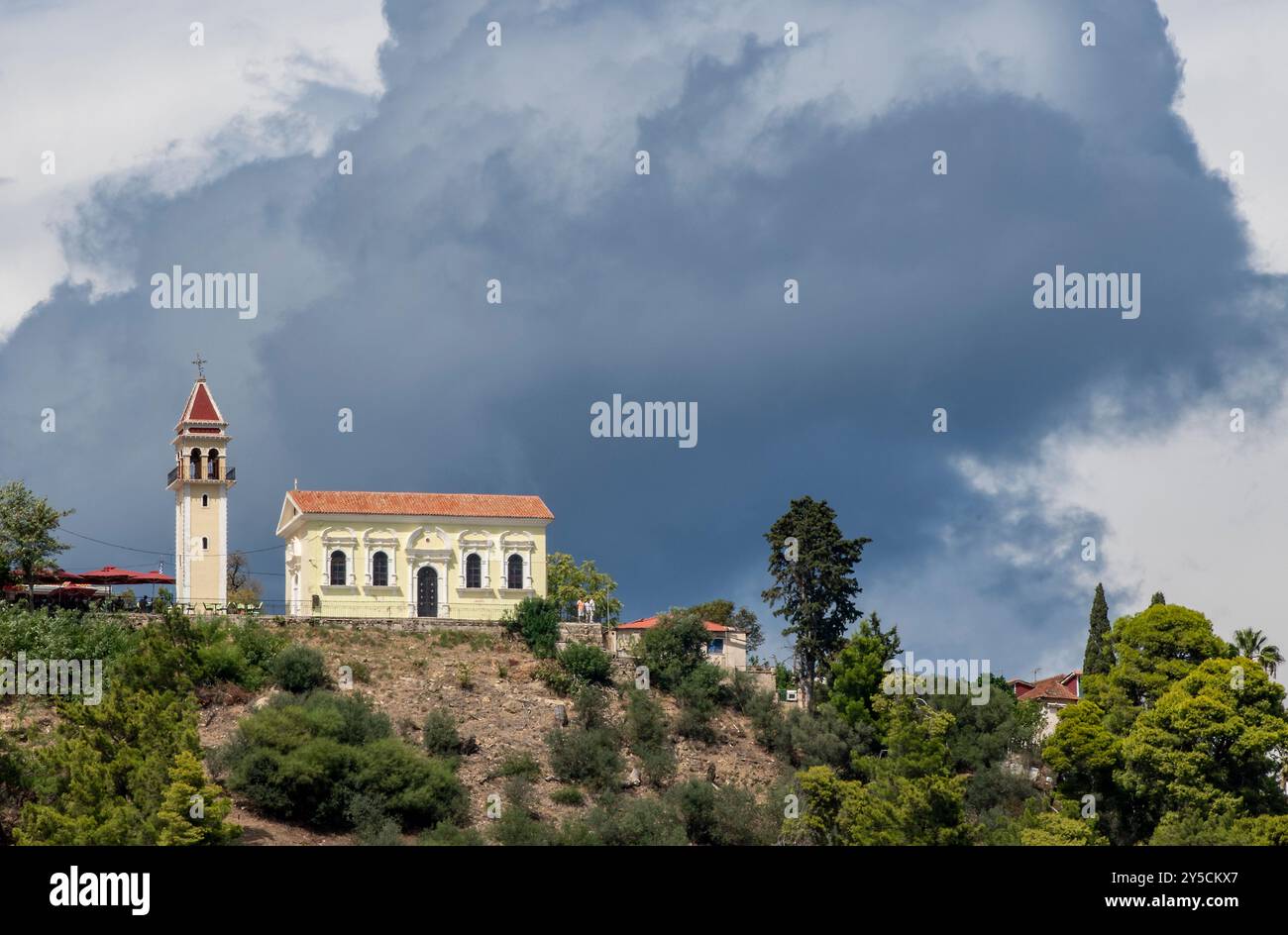 Stürmischer Himmel über einer griechischen orthodoxen Kirche mit einer großen schwarzen Wolke über dem Hügel in Zakynthos Stadt Griechenland Stockfoto