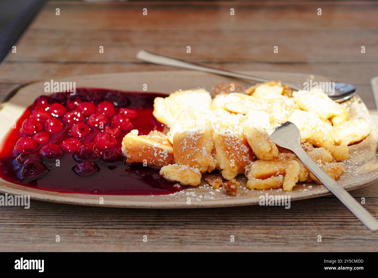 Traditioneller österreichischer hausgemachter Kaiserschmarren serviert mit Roter Grütze (süß-saure Sauce aus Beerenfrüchten ) Stockfoto