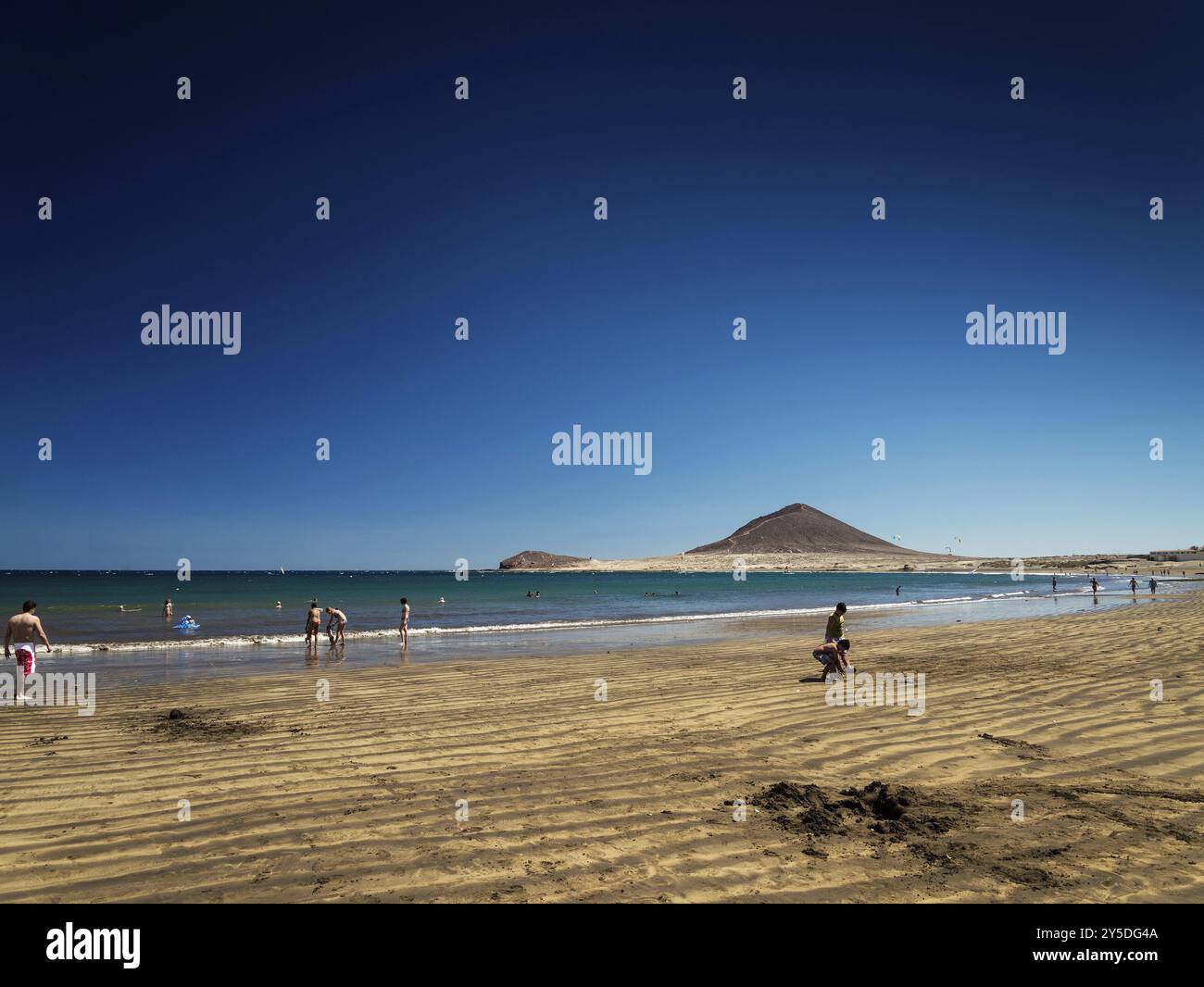 Toursisten am Strand El medano und am Wahrzeichen des Berges montana roja im Süden teneriffas spanien Stockfoto