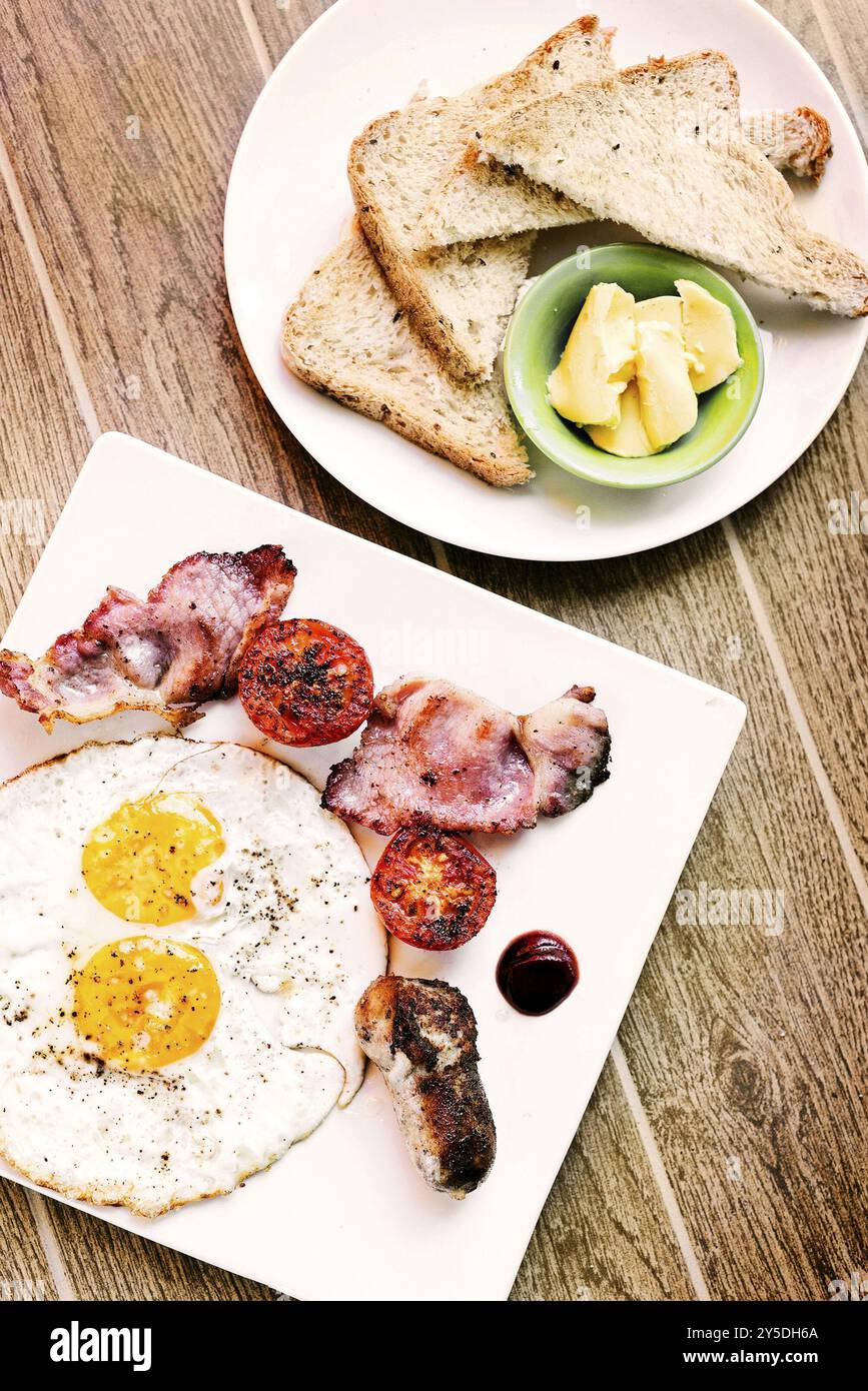 Traditionelles klassisches englisches Bratfrühstück mit Eiern, Speck, Tomatenwurst und Toast Stockfoto