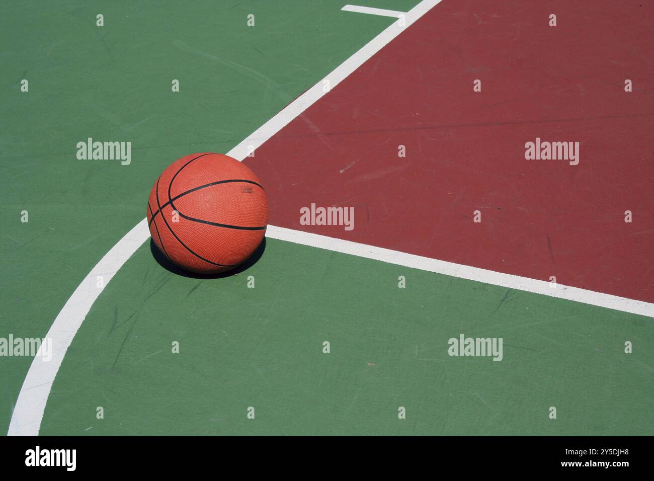 Ein Basketball an der freien Throwlinie auf roten und grünen Hof Stockfoto