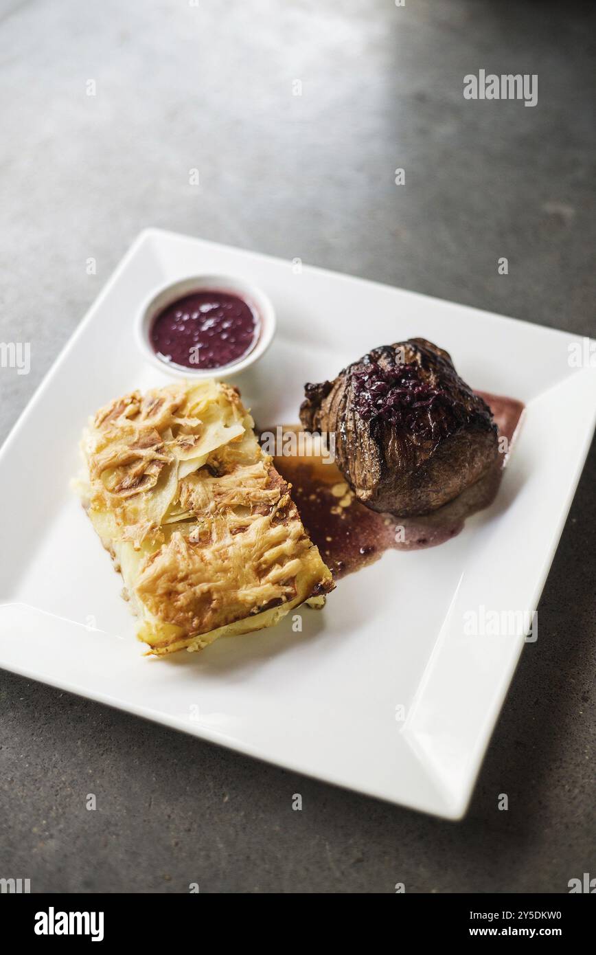 Rindersteak mit Kartoffeln, Zwiebeln und Käse Stockfoto