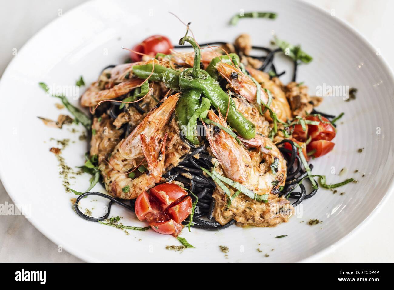 Gourmet-Essen gegrillte Garnelen und Gemüse auf Pasta-Mahlzeit mit schwarzer Tintenfisch-Tinte Stockfoto