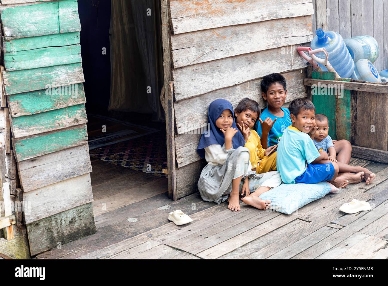 Verspielte, freundliche und lächelnde einheimische Bajau-Kinder voller Neugier, die den authentischen Seezigeuner-Geist im Labengki-Archipel einfangen. Stockfoto