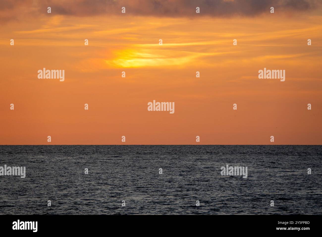 Sonnenuntergang über dem Mittelmeer aus Livorno, Italien, mit sanften Orangentönen, die sich in den Horizont einfügen. Stockfoto