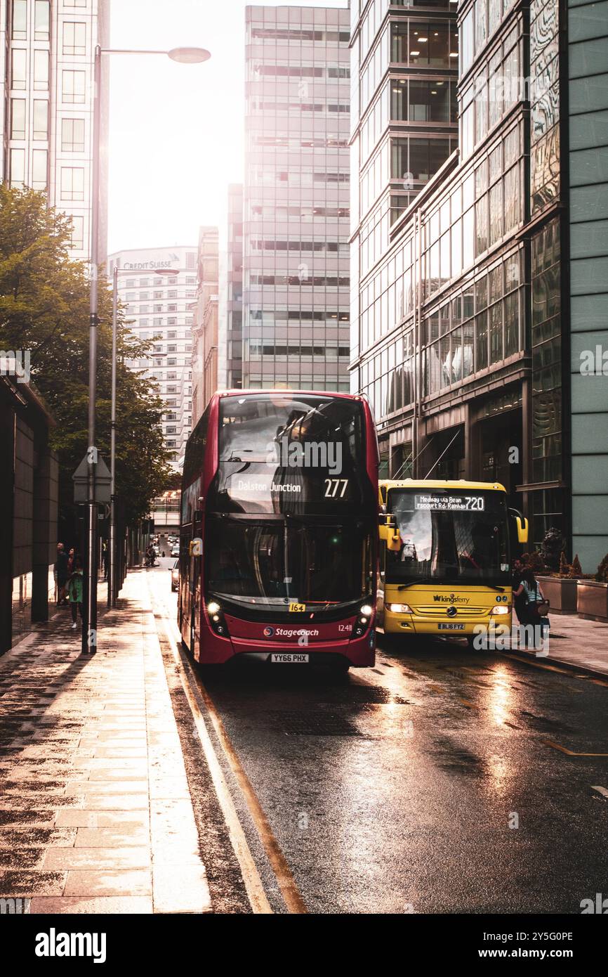 Busse mit öffentlichen Verkehrsmitteln in Canary Wharf, London bei Sonnenuntergang. Stockfoto