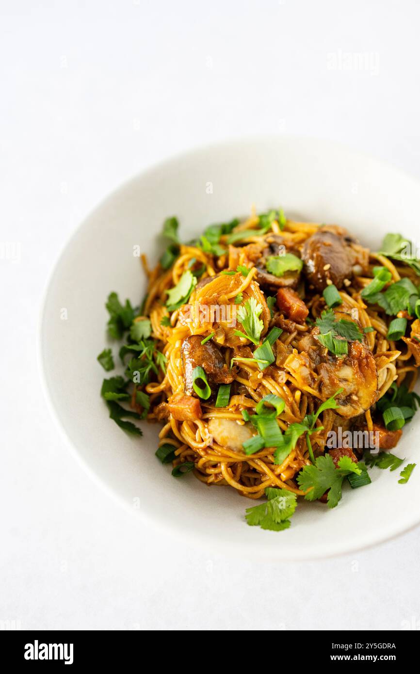 Nudeln mit Lauch, Pilzen, iberischem Schinken und „Dan Dan Dan“-Sauce Stockfoto
