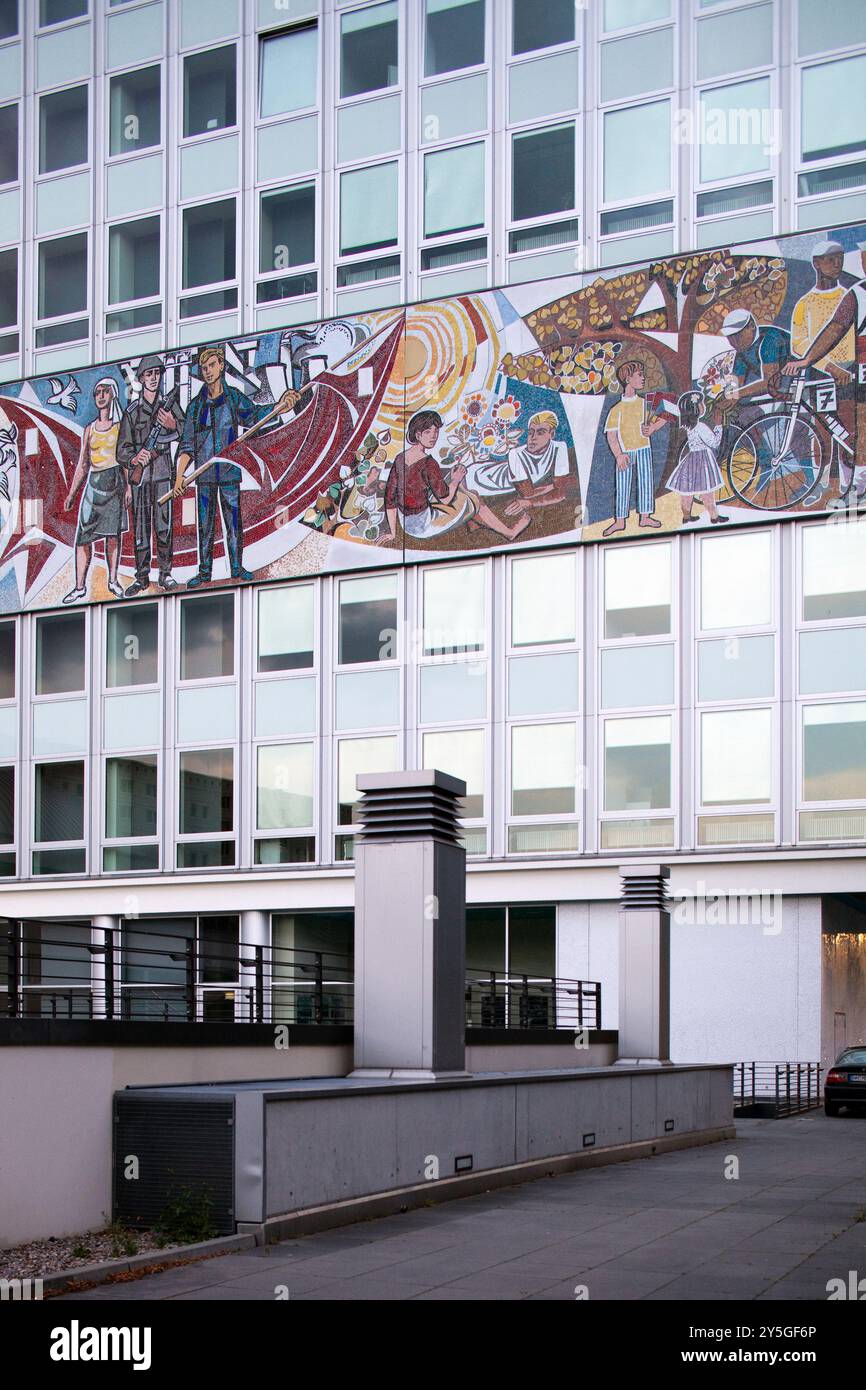 Das Haus des Lehrers zeigt ein lebendiges sozialistisches Wandbild, das den Alltag und die Gemeindeaktivitäten in Berlin darstellt. Stockfoto