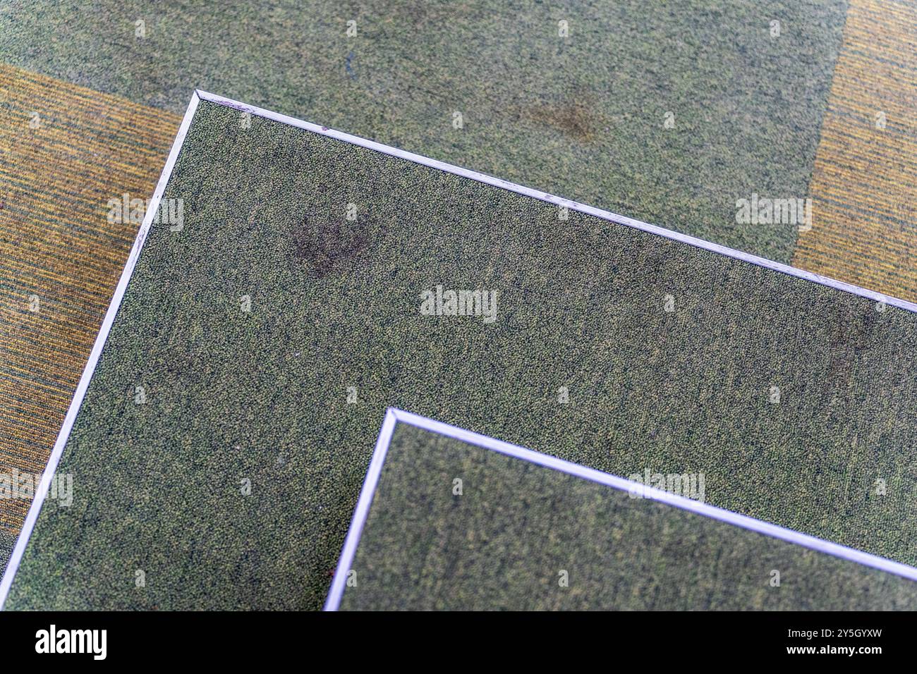 Abstrakte Luftlandschaft: Grüner Wandteppich im Inneren mit weißen Kanten und schmutzigem Boden Stockfoto