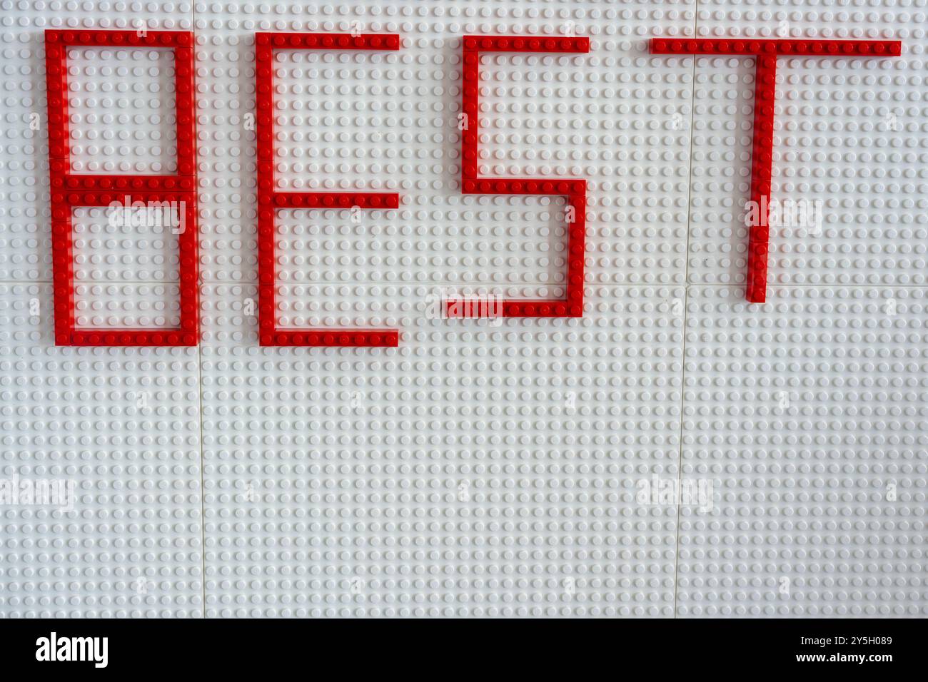 Kreativer Ausdruck der Wertschätzung: Rechtschreibung „am besten“ mit roten Plastikwürfeln. Weißer Hintergrund. Stockfoto