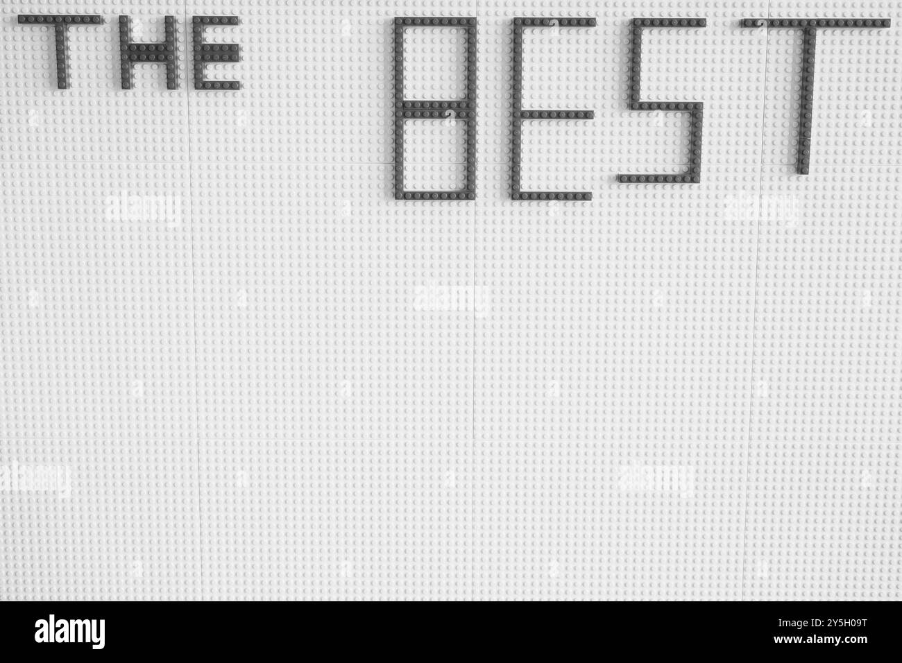 Kreatives Zeichen der Wertschätzung: Mit Plastikwürfeln „das Beste“ schreiben. Schwarz-weiß. Stockfoto