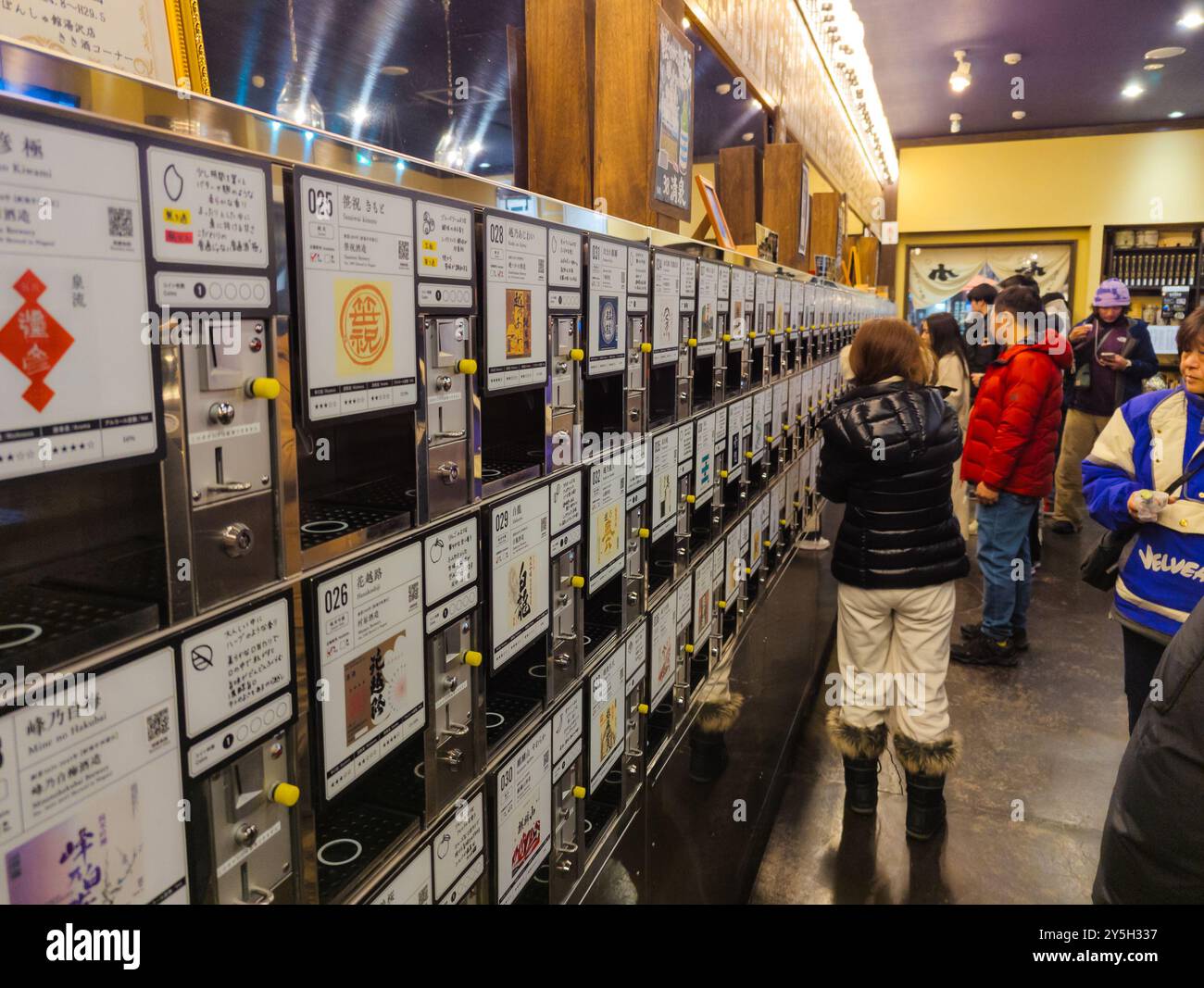 Besucher probieren bis zu 100 Sake-Sorten aus Automaten in der japanischen Station Echigo-Yuzawa Stockfoto