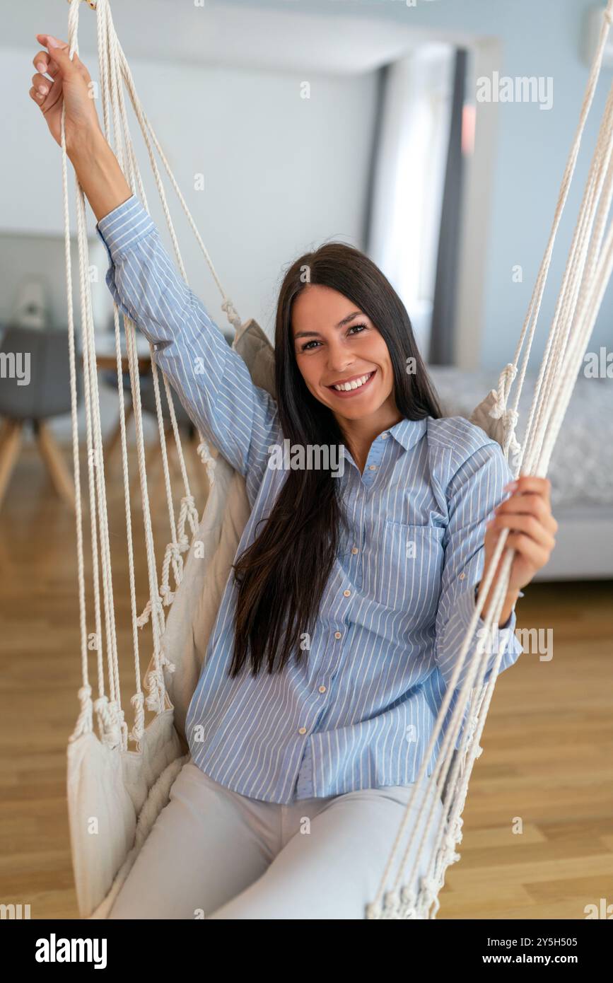 Junge lateinfrau mit ausgestreckten Armen, die frische Luft atmen und friedliches Gleichgewicht genießen Stockfoto