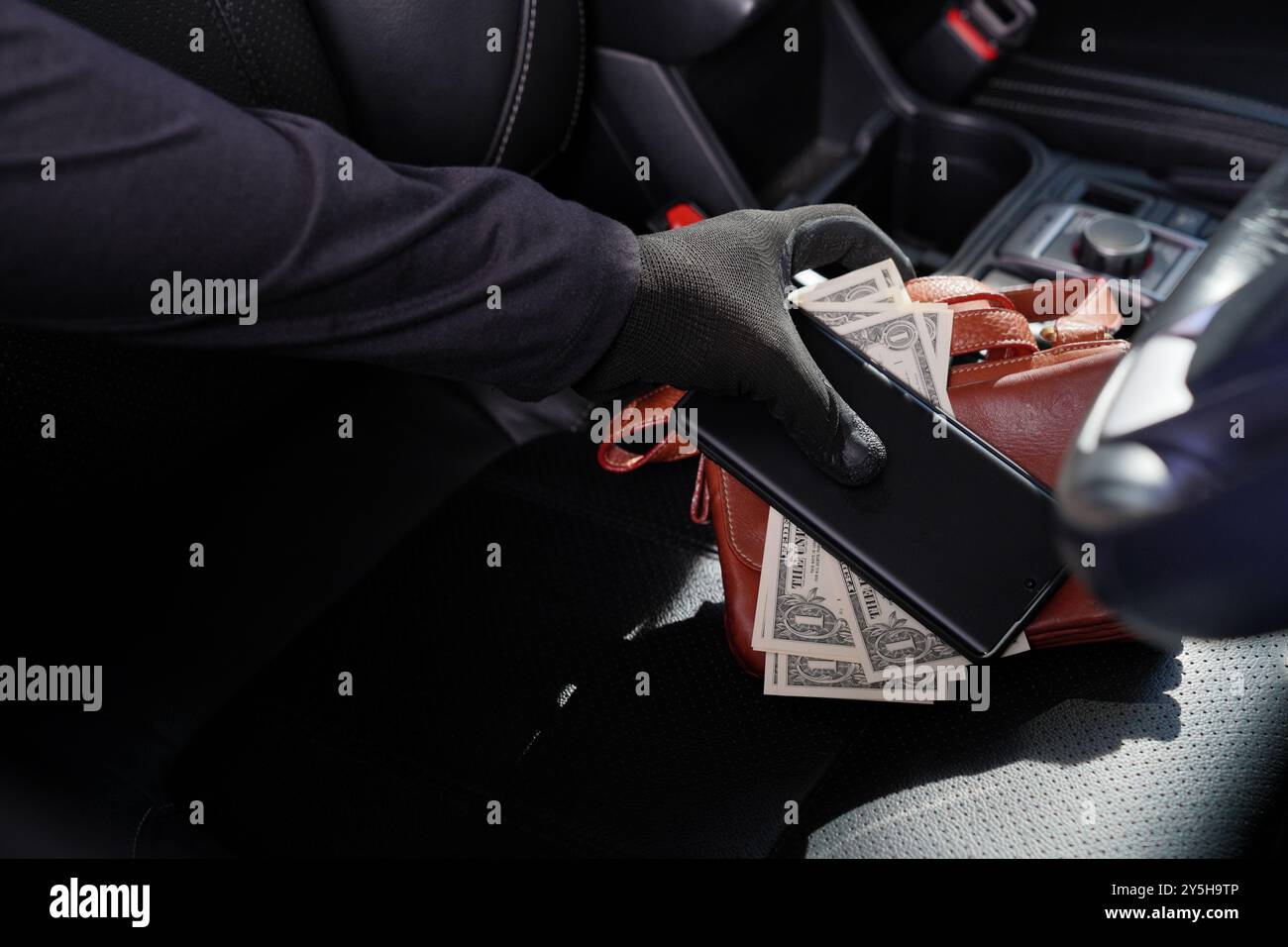 Ein Dieb stiehlt Wertsachen, die im Auto liegen Stockfoto