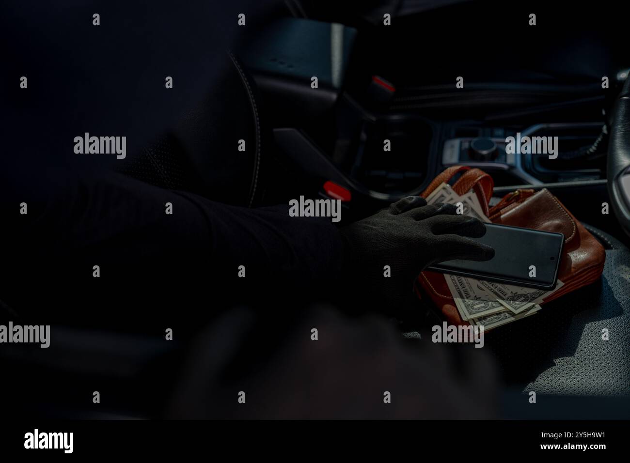 Ein Dieb stiehlt Wertsachen, die im Auto liegen Stockfoto