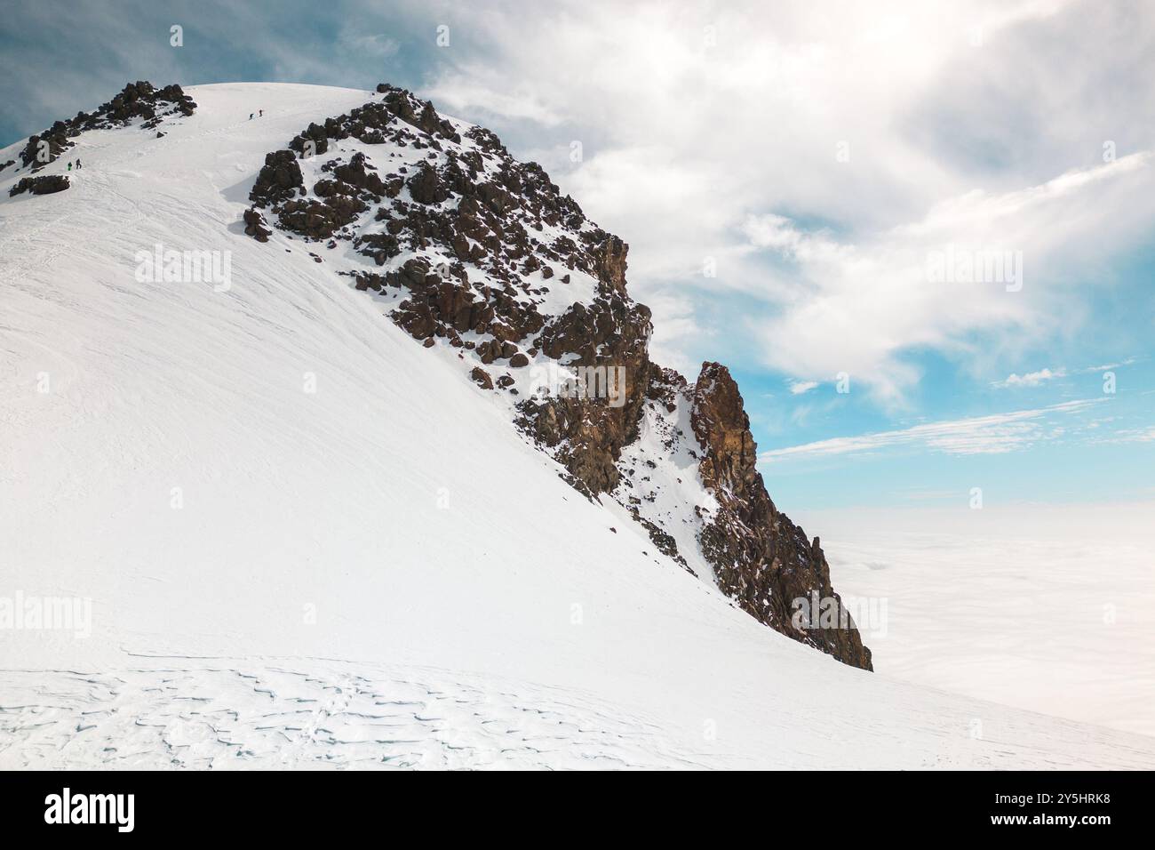 Gruppe von Kletterern erreicht den Gipfel Kasbeks in Georgien. Geben Sie niemals auf und durchdrängen Sie das Konzept der Lebensschwierigkeiten. Mann, der hart arbeitet, um einen Mo hinaufzuklettern Stockfoto