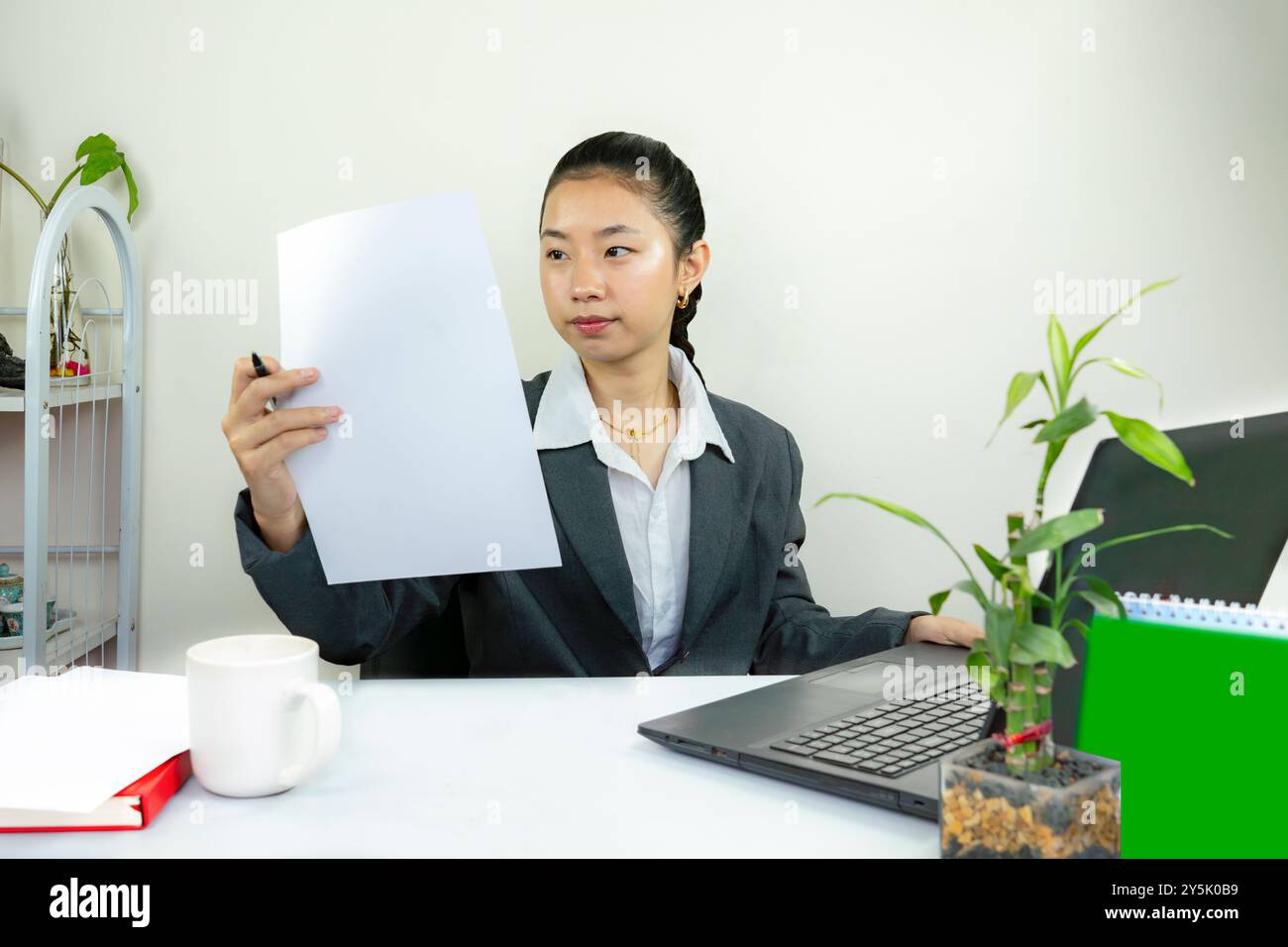 Attraktive asiatisch-chinesische weibliche junge Managerin in formeller Kleidung im Büro gibt Gesten Wow Happy with Calendar Mockup Stockfoto