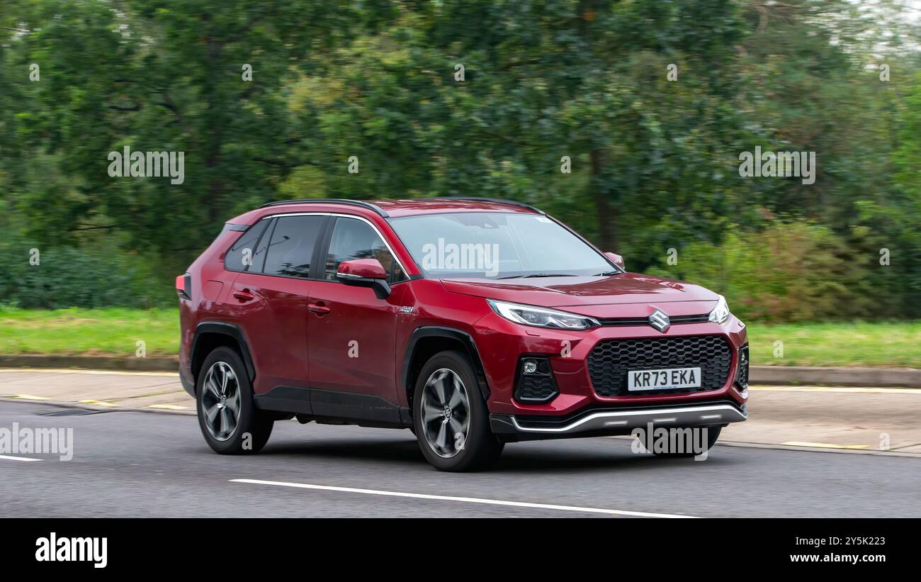 Milton Keynes, Großbritannien - 22. September 2024: 2023 rote Suzuki über E-Four-Hybrid-Elektroauto, das auf einer britischen Straße fährt Stockfoto