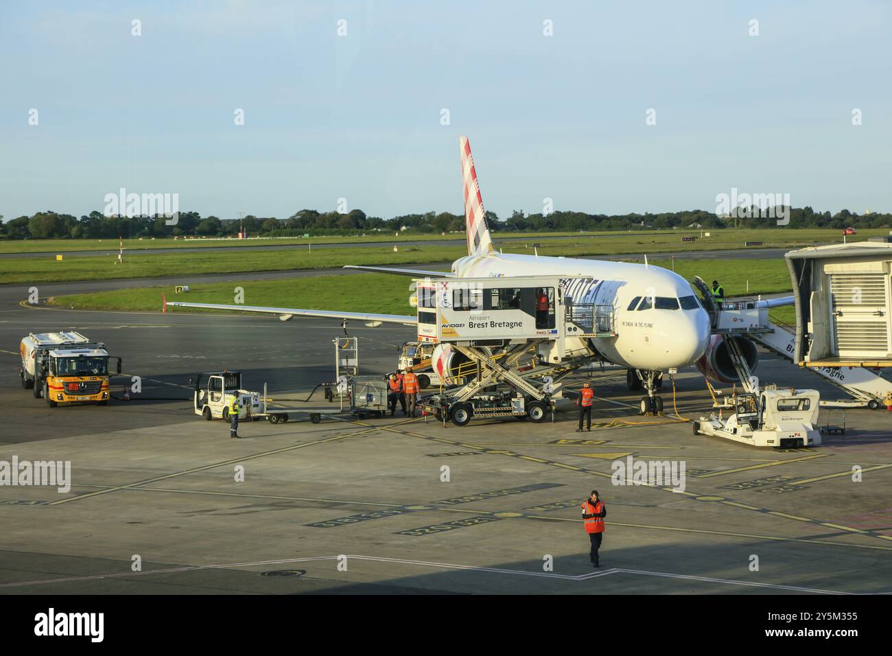 Airbus der spanischen Fluggesellschaft Volotea mit speziellem Fahrzeug-Lift für behinderte Rollstuhlfahrer und Shell-Tanker am Flughafen Aeroport Brest Bretagne, Fin Stockfoto