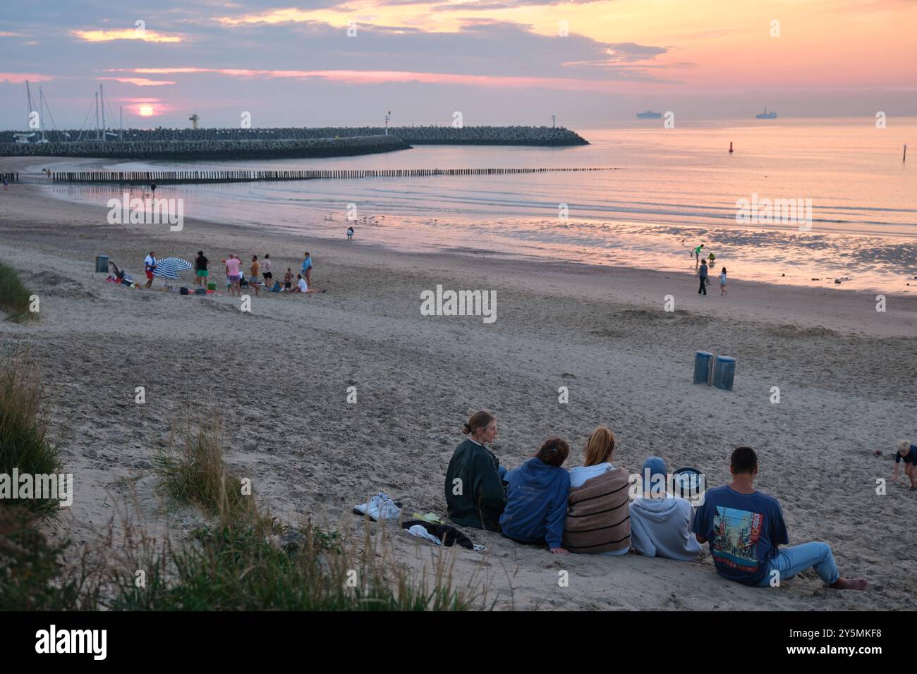 Menschen beobachten den Sonnenuntergang über dem Strand von Cadzand in Zeeland, Südholland Stockfoto