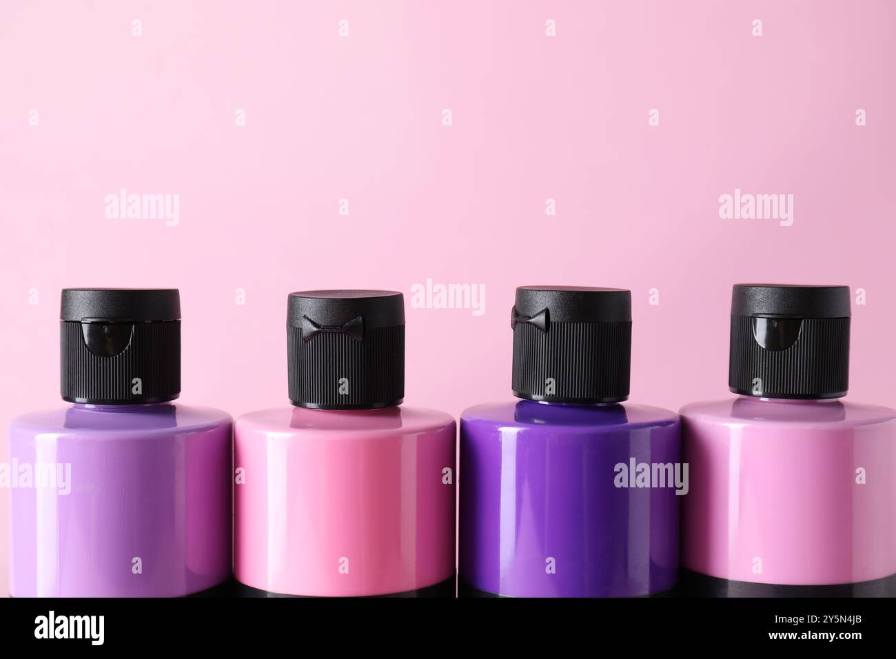 Acrylfarben in verschiedenen Farben auf rosa Hintergrund, Nahaufnahme Stockfoto