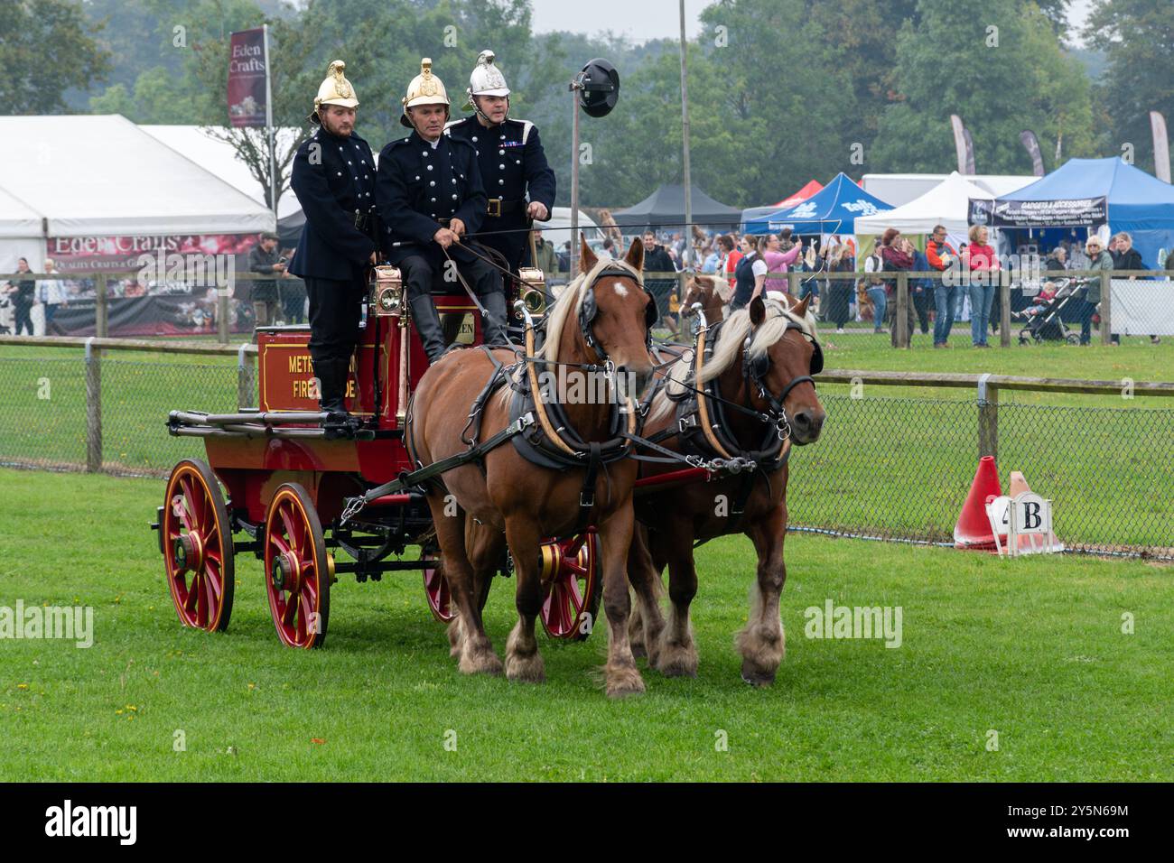 Newbury Show, 21. September 2024. Die beliebte jährliche Veranstaltung fand am Wochenende auf dem Newbury Showground in Berkshire, England, Großbritannien, statt. Die Show umfasst eine Vielzahl von berühmten, kulinarischen und ländlichen Ausstellungen und zieht Tausende von Besuchern an. Im Bild: Schwere Pferde in der Hauptarena, mit einem alten Feuerwehrauto und Feuerwehrleuten in altmodischer Uniform Stockfoto