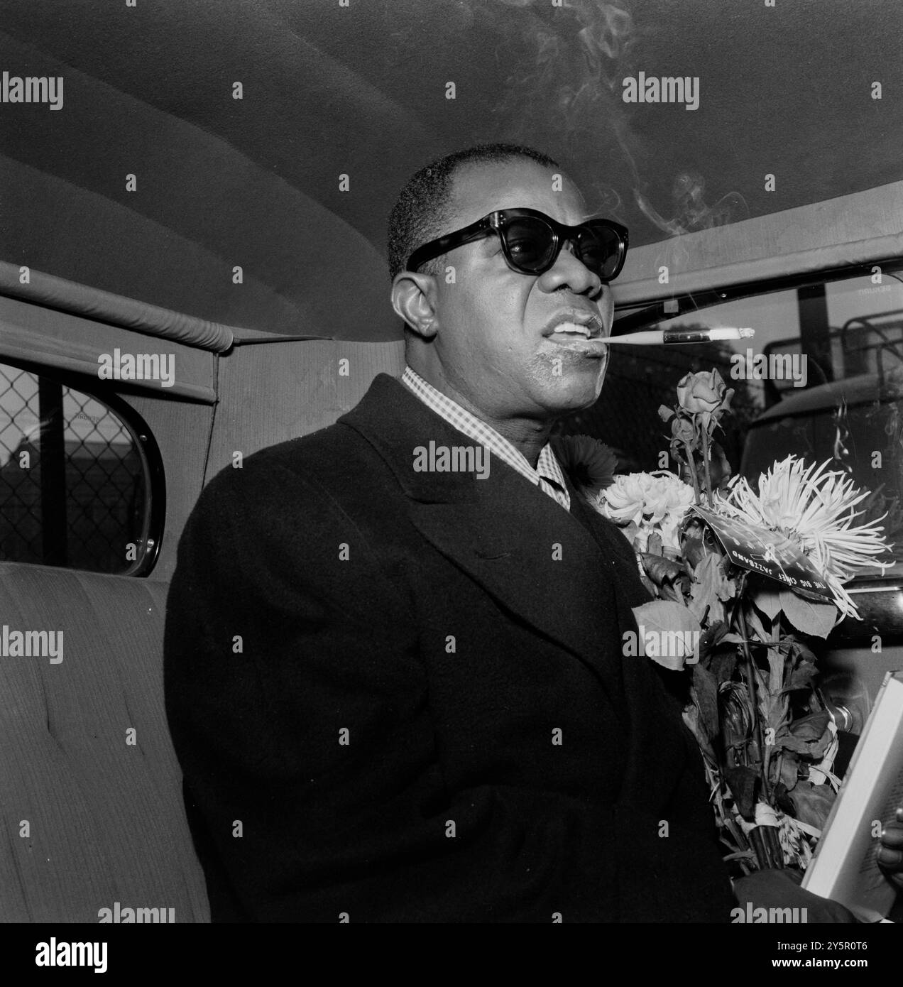 Amerikanische Jazz-Legende Louis Armstrong mit Sonnenbrille, Rauchen in einem Auto in Oslo - 1955 Stockfoto