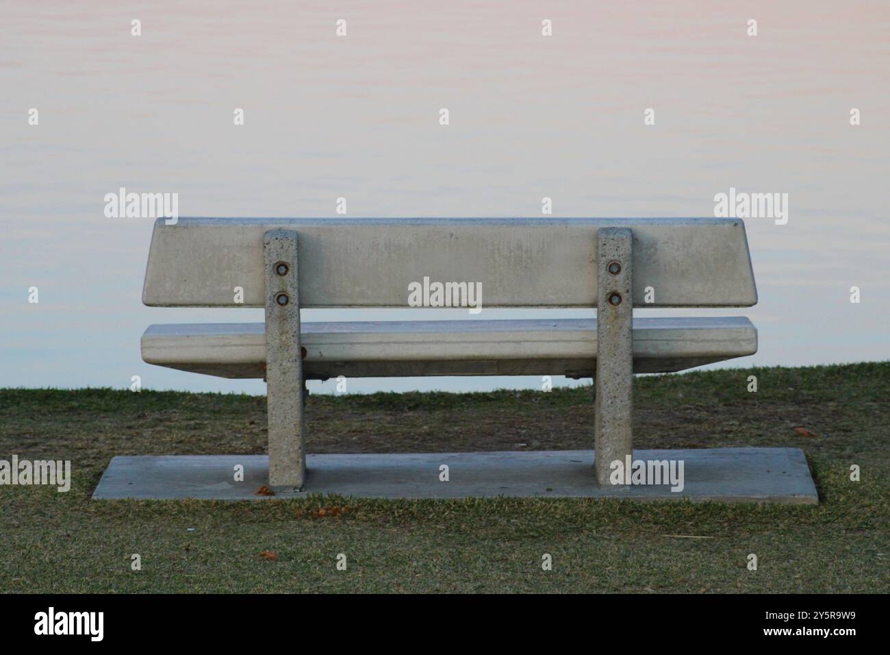 Leere Steinbank am Wasser Stockfoto