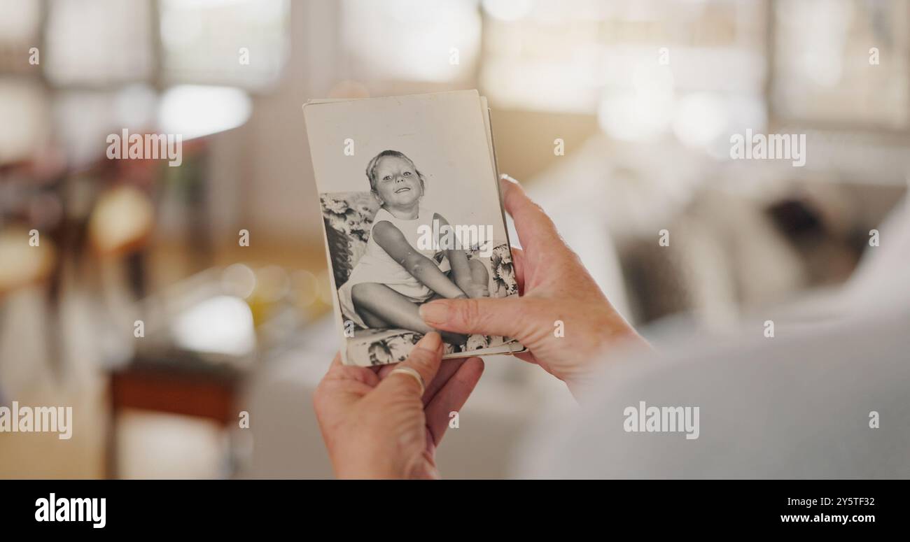 Hand, Nostalgie und Seniorin mit Bilderrahmen für Trauer, Verlust oder Trauer mit Geschichte im Haus. Komfort, Gedächtnis und älterer Patient mit Foto Stockfoto