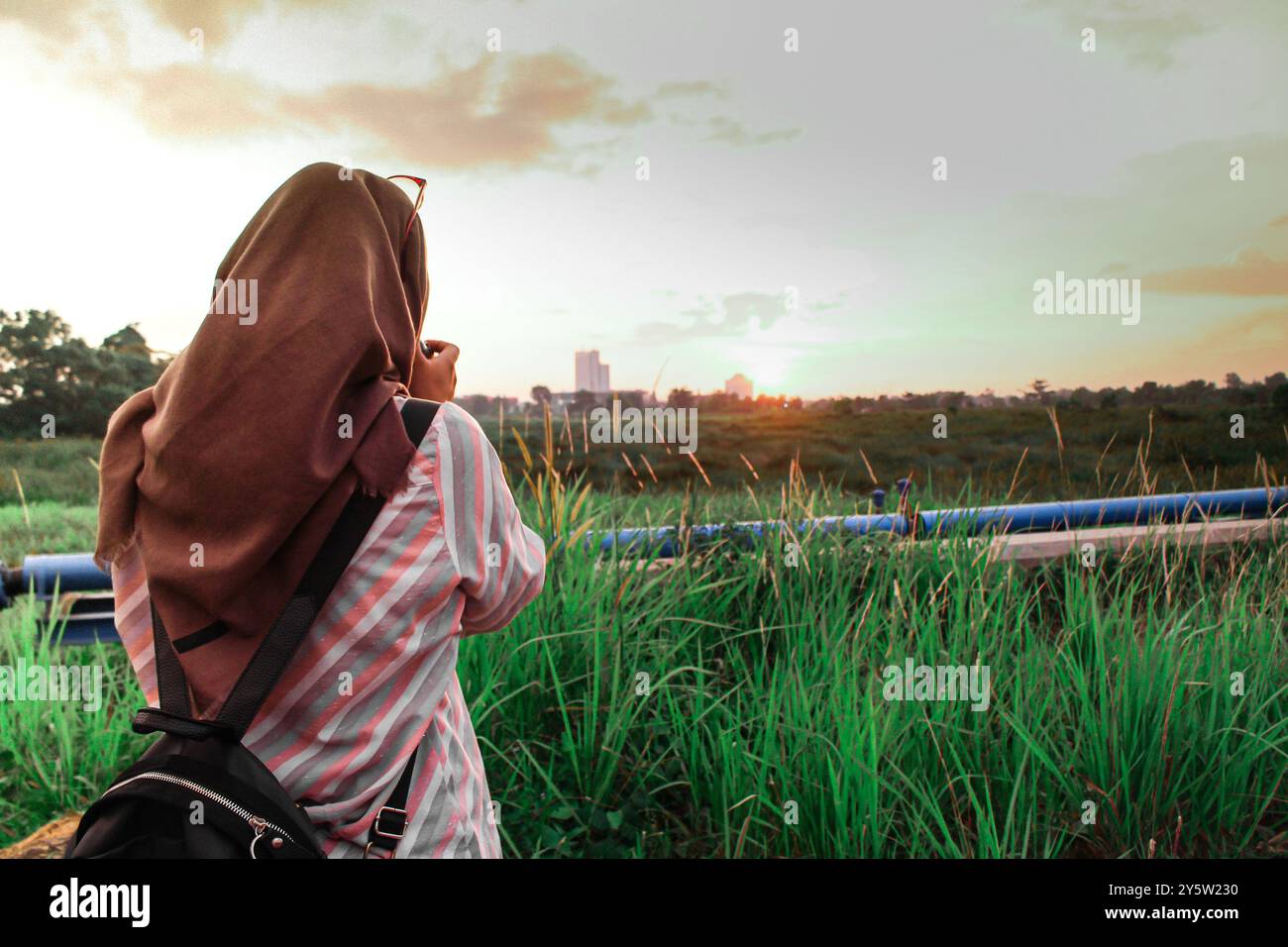 PHOTOGRAPER GIRL MACHT EIN FOTO VOM SONNENUNTERGANG Stockfoto