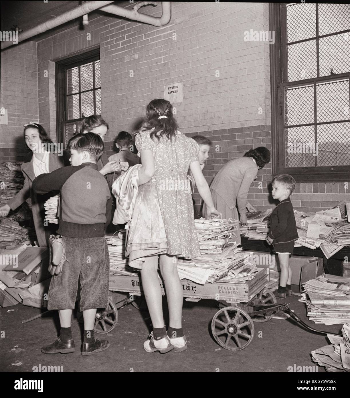 Amerika der 1940er Jahre Schrottschrottkampagne, Siegesprogramm. Schulkinder bringen ihr Altpapier aus ihren Klassenzimmern in den Keller, wo es von einem Papierfabrikwagen abgeholt wird. USA. Washington, D.C. Mai 1942 von M. Collins, Fotograf Stockfoto