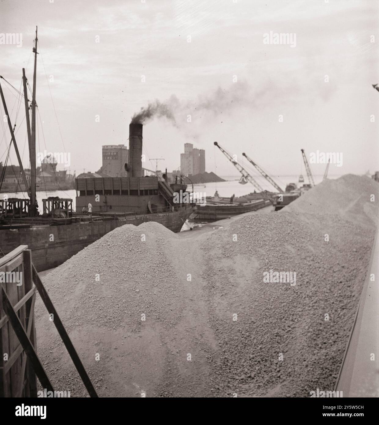 Amerika der 1940er Jahre Entladung von Bauxit von einem Lastkahn auf ein kanadisches Boot, das von Niederländisch-Guayana aus über die Binnenwasserstraßen heraufgestiegen ist. Oswego, New York. Juni 1943 Stockfoto