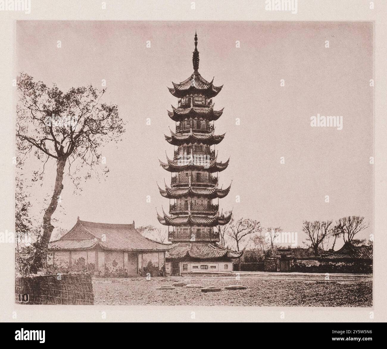 Vintage-Foto der Longhua-Pagode im Bezirk Xuhui. Shanghai, Ostchina. Illustrations of Qing China, 1875 Longhua Pagode ist eine achteckige Holz- und Ziegelpagode. Es wird angenommen, dass es während der drei Königreiche (East Wu) erbaut wurde, aber die bestehende Turmstruktur wurde während der Northern Song Dynastie gebaut. Die Pagode wurde in verschiedenen Dynastikperioden mehrfach renoviert, was dazu führte, dass mehrere architektonische Elemente hinzugefügt wurden, die nicht dem typischen Stil der Song-Dynastie entsprachen. Die Pagode auf diesem Foto ist 120 Meter hoch. Er wird von einer verwinkelten Treppe hinaufgestiegen Stockfoto