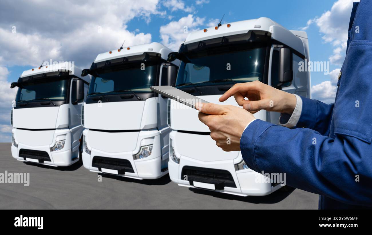 Fuhrparkmanager mit digitalem Tablet auf einem Hintergrund von Lkws Stockfoto