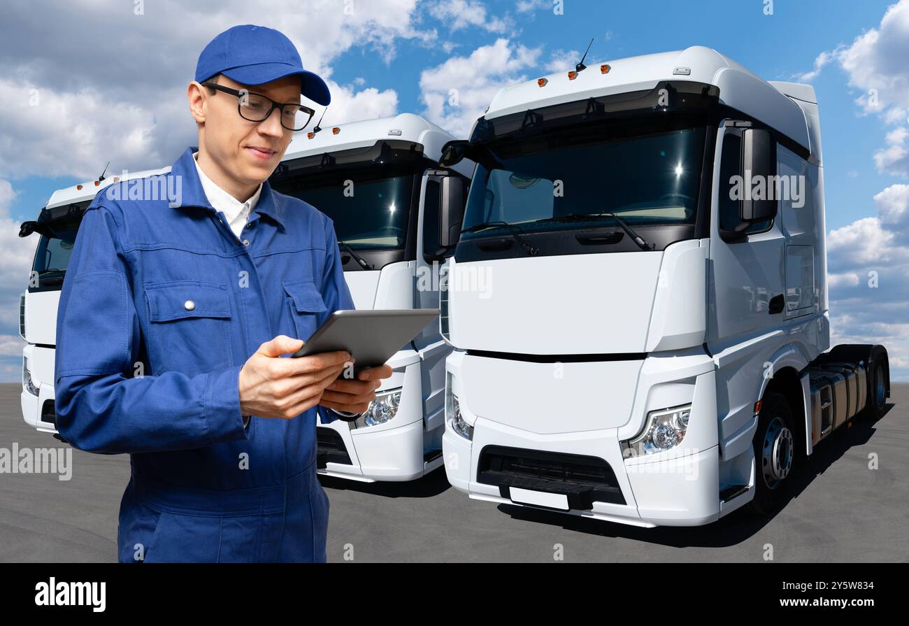 Fuhrparkmanager mit digitalem Tablet auf einem Hintergrund von Lkws Stockfoto