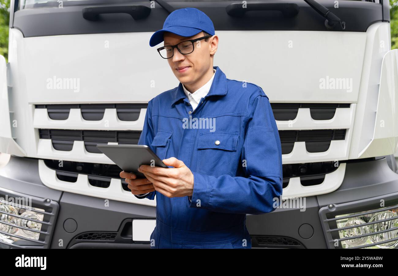 Fuhrparkmanager mit digitalem Tablet auf einem Lkw-Hintergrund. Stockfoto