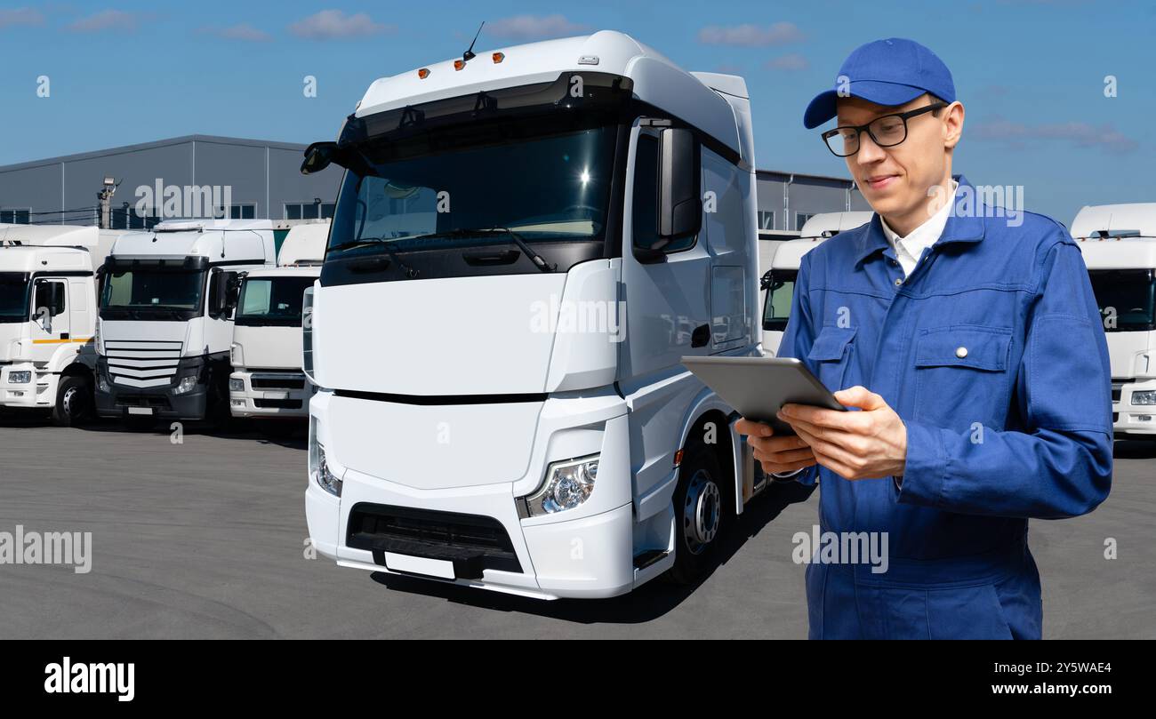 Fuhrparkmanager mit digitalem Tablet auf einem Hintergrund von Lkws Stockfoto