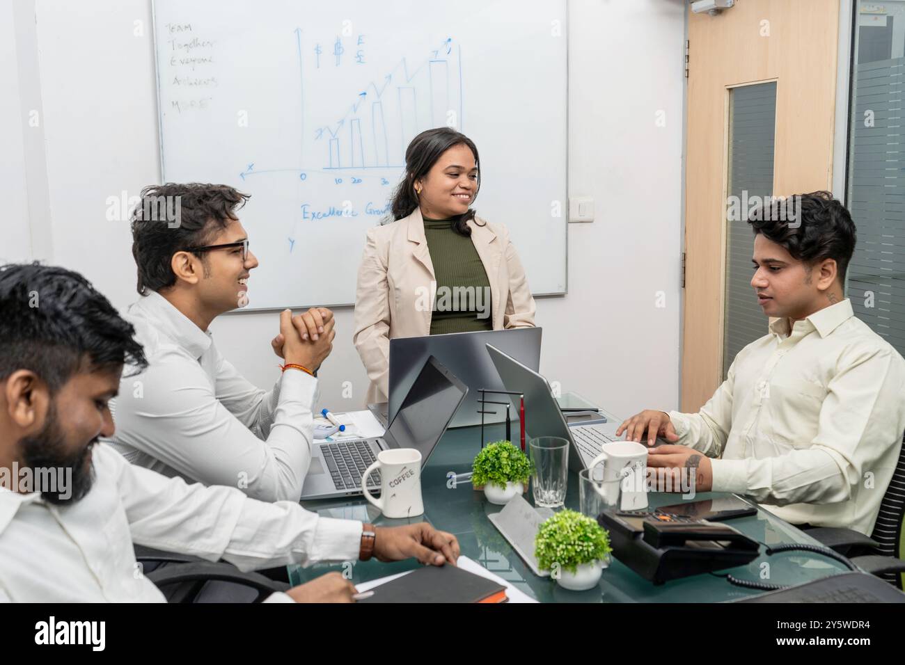 Corporate Meeting Room mit lebhaften Diskussionen unter Kollegen über den Fortschritt des Unternehmens und den Austausch von Produktwissen Stockfoto