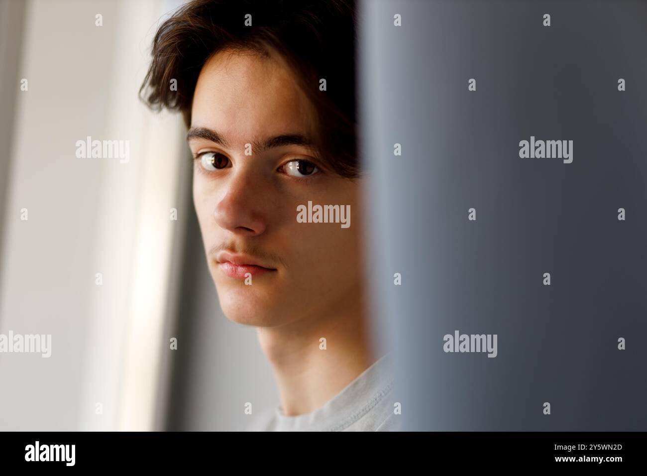 Porträt kontemplativer Jugendlicher am Fenster Stockfoto