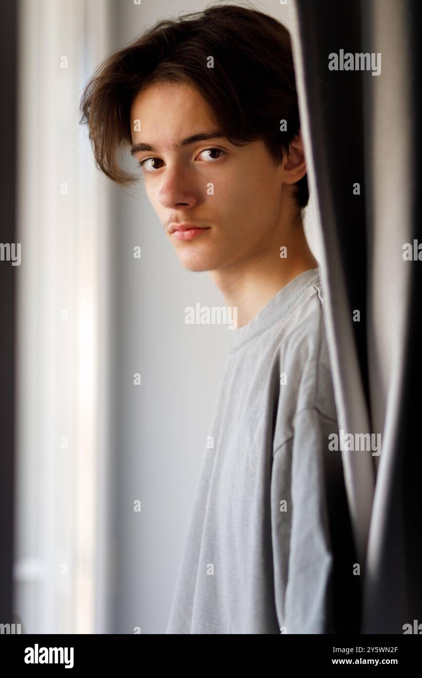 Porträt kontemplativer Jugendlicher am Fenster Stockfoto