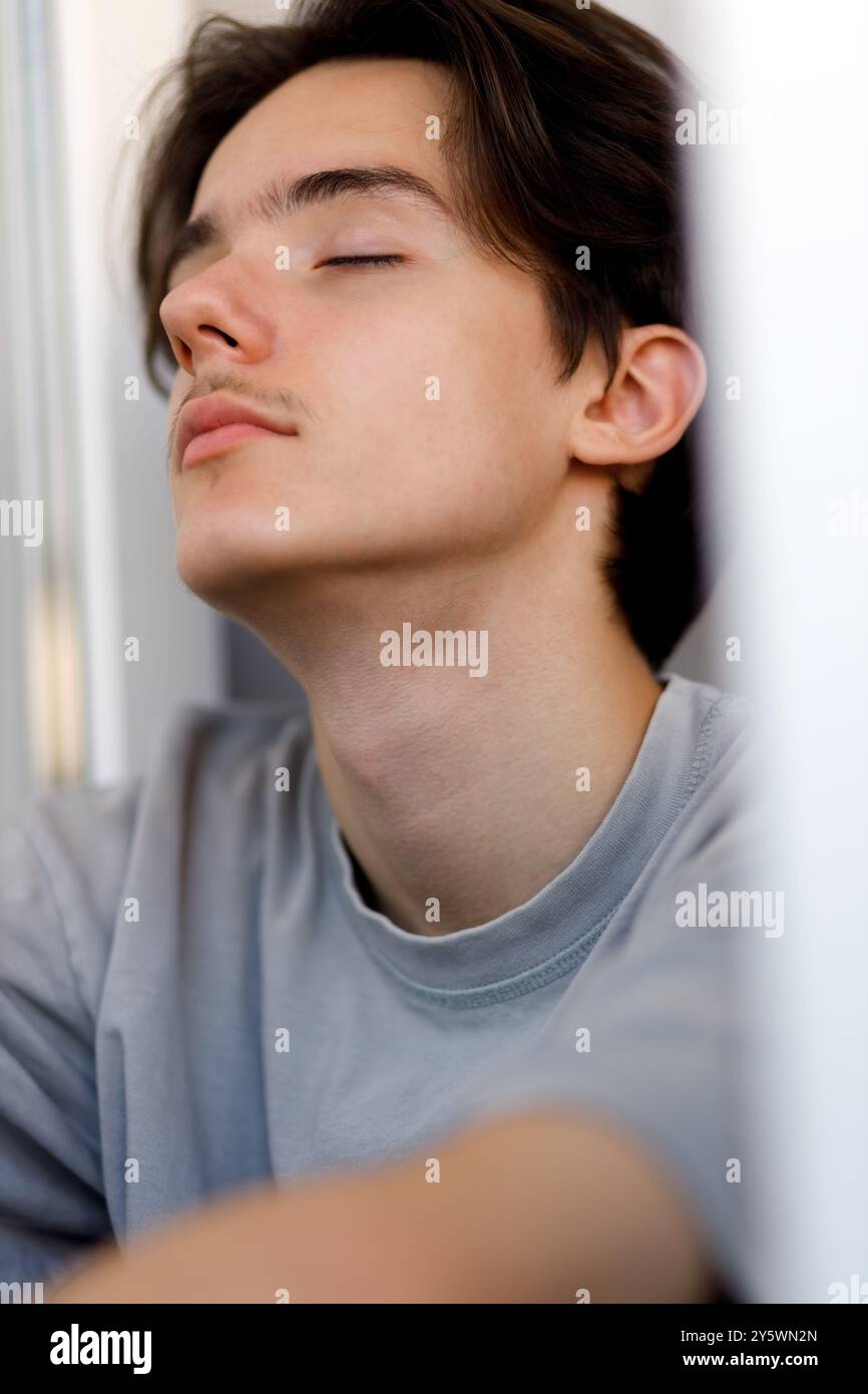 Ein ruhiger junger Mensch reflektiert sich in einem friedlichen Moment Stockfoto