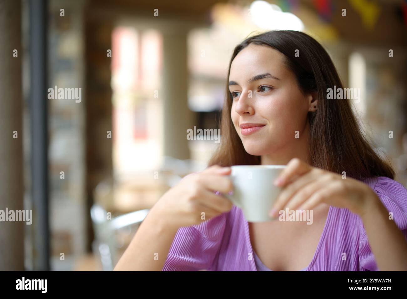 Zufriedener Bargast, der Kaffee trinkt und auf einer Terrasse wegblickt Stockfoto