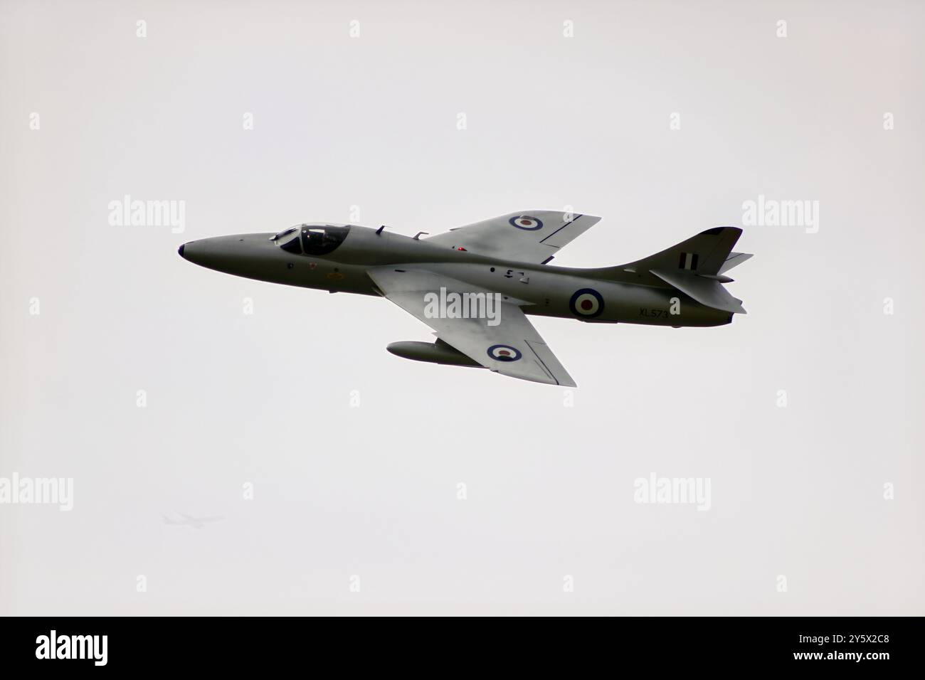 Ein Vintage-Militärflugzeug im Flug gegen einen klaren Himmel, das sein Design und seine Markierungen zeigt. Stockfoto