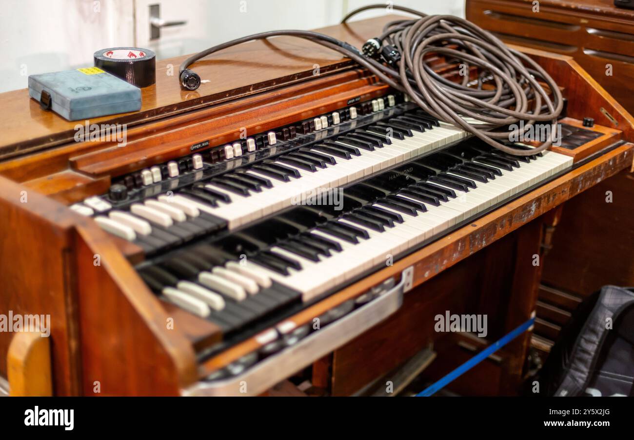 Vintage elektrische Orgel mit mehreren Tastaturen und einem Spiralkabel oben. Stockfoto