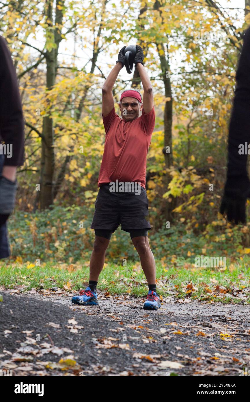 Reifer Mann in Sportbekleidung, der mit Kettlebell in einem Park trainiert. Stockfoto