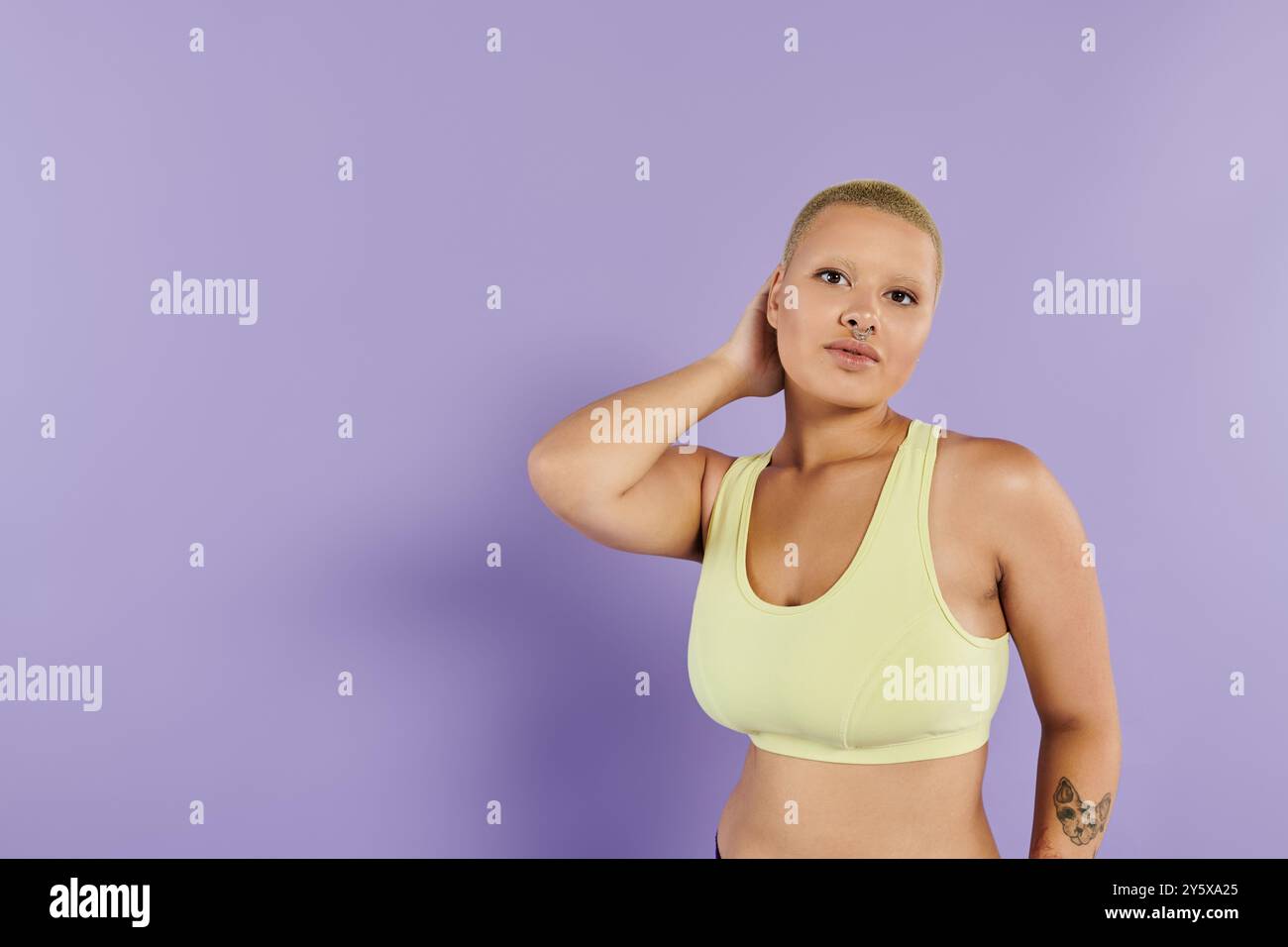 Eine selbstbewusste junge Frau in hellen Gewändern drückt sich mit einer fesselnden Pose aus. Stockfoto