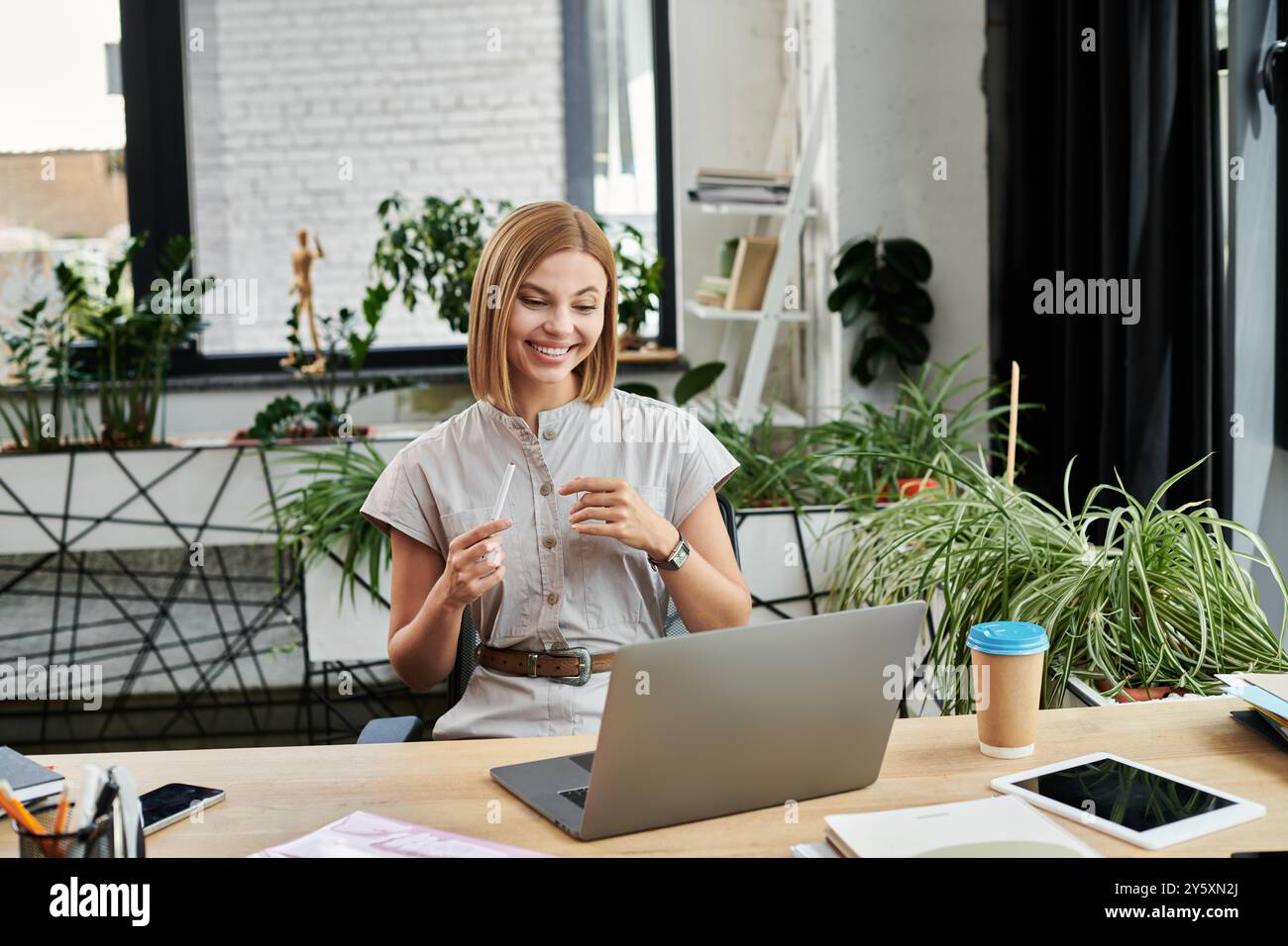 Ein junger Berufstätiger nimmt mit Begeisterung an einem virtuellen Treffen Teil, umgeben von Grün. Stockfoto