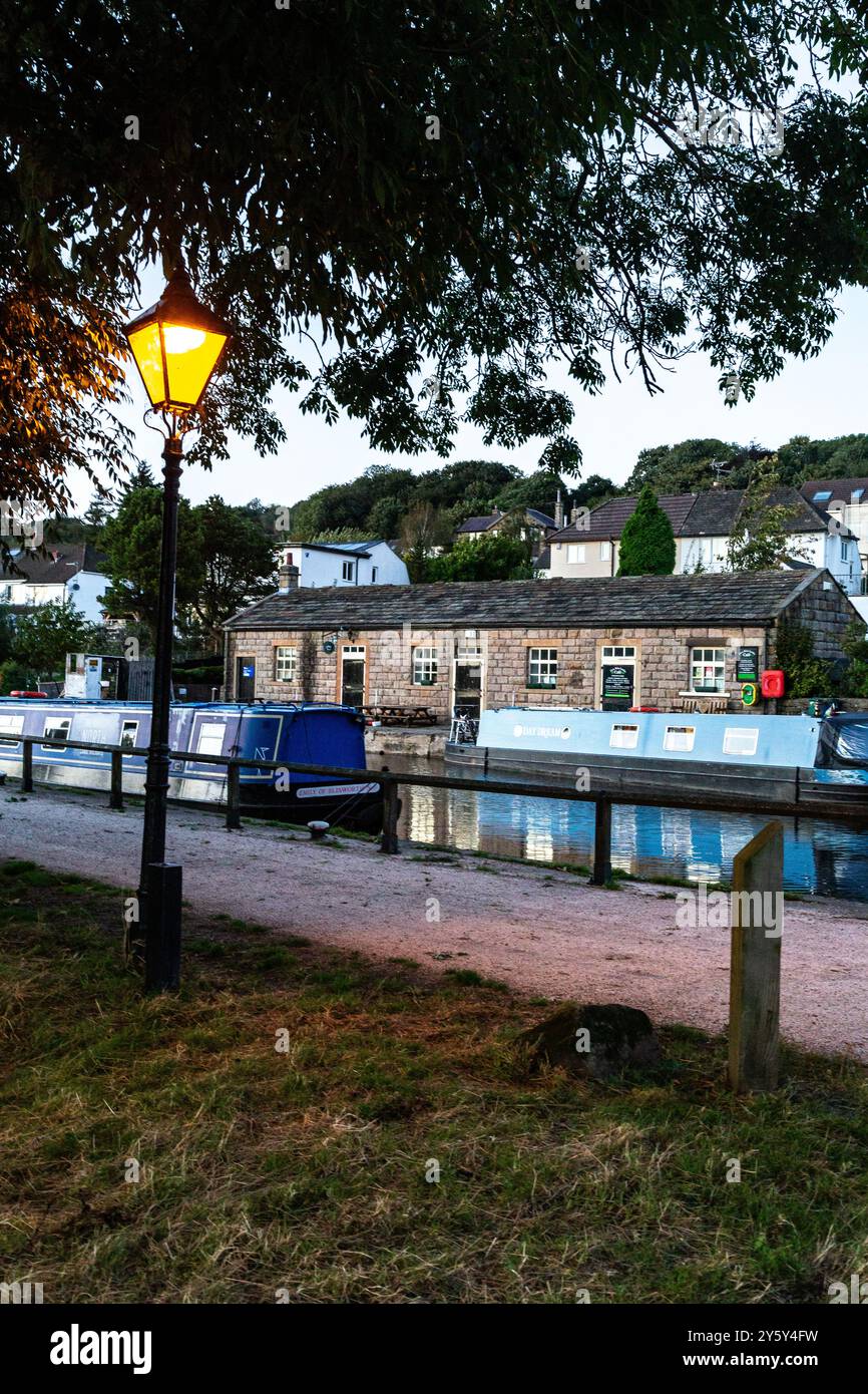 Der Leeds & Liverpool Canal an der Spitze der Five Rise Locks in Bingley, Yorkshire, im Abendlicht. Das Five Rise Cafe ist im Hintergrund. Stockfoto