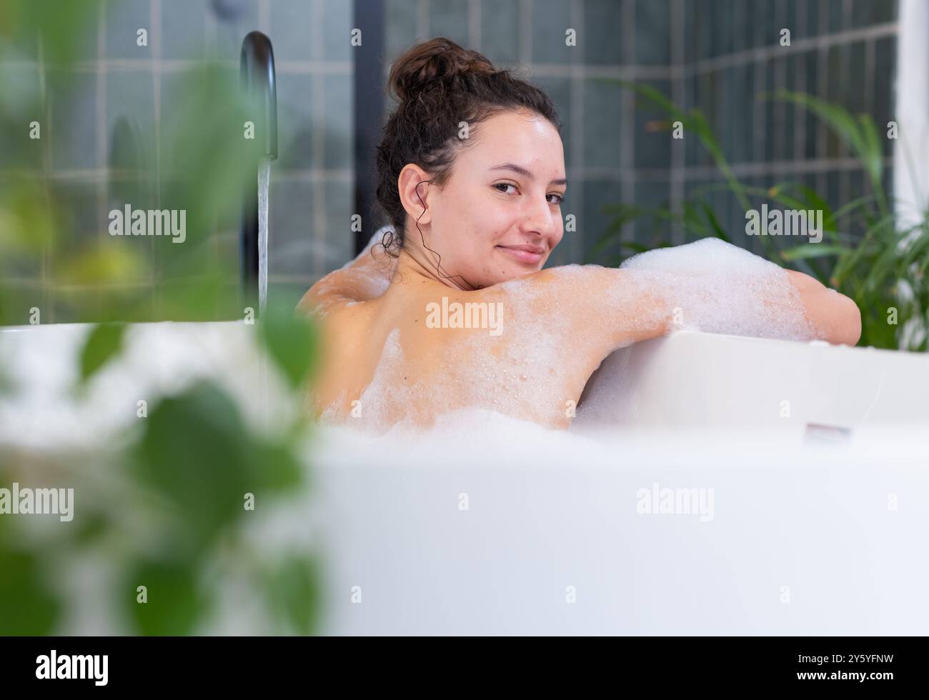 Entspannen Sie sich in der Badewanne mit Seifenblasen, Frau genießt einen Spa-Tag zu Hause Stockfoto