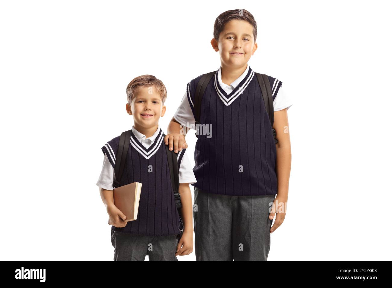 Zwei Schuljungen in Uniform, die sich isoliert auf weißem Hintergrund posieren Stockfoto